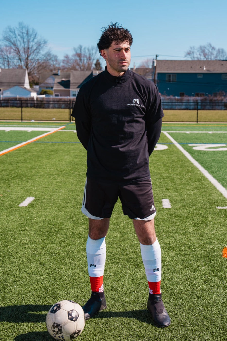 MediCaptain player standing on a turf field next to a soccer ball